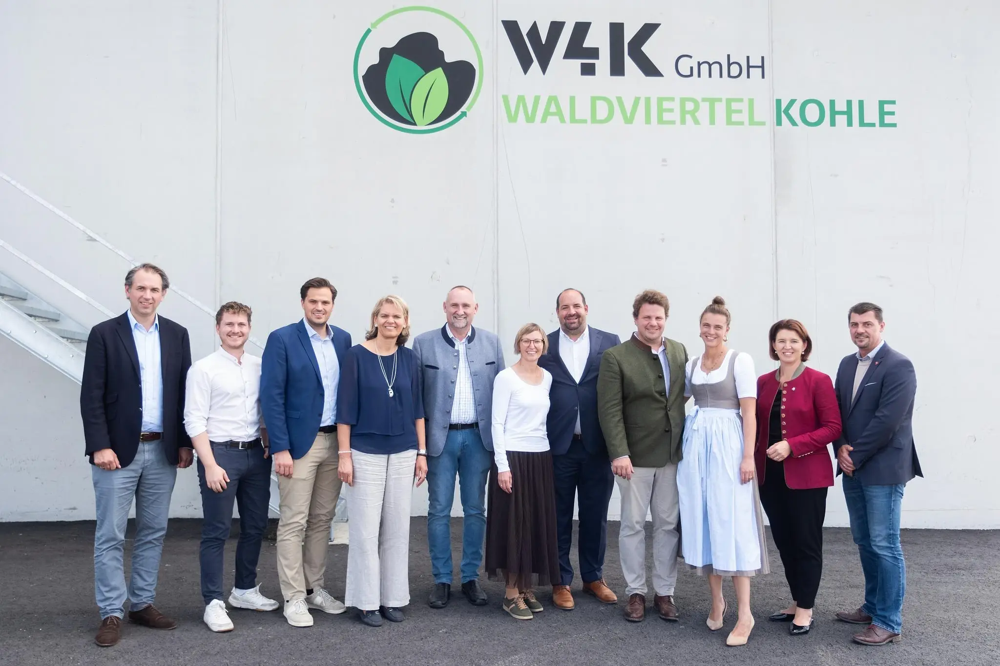 Gruppenfoto zur Eröffnung: elf Personen vor der Anlage, darüber der Schriftzug „W4K GmbH Waldviertelkohle“